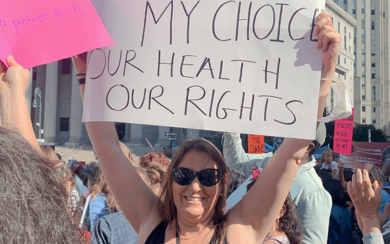 woman holding up a sign that says my choice our health our rights at a reproductive rights march